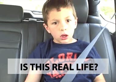 A boy sits buckled into a car seat beneath the caption “IS THIS REAL LIFE?”
