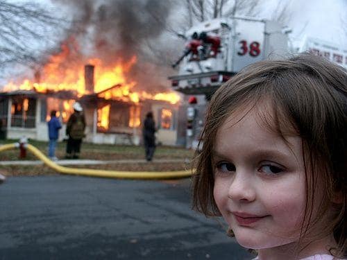 Disaster Girl photo with smiling child in front of a burning house