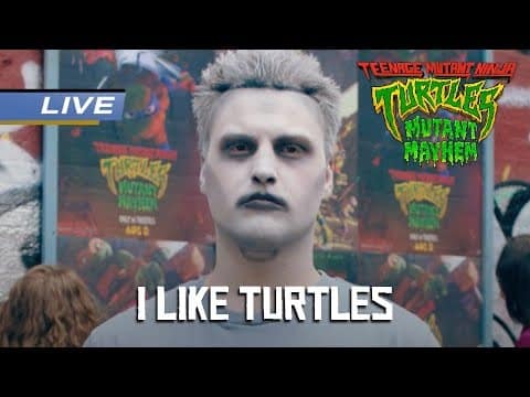 An adult with pale face paint and dark eye makeup stands before Teenage Mutant Ninja Turtles promotional posters. A large caption reads “I LIKE TURTLES.”