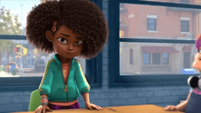 Karma standing beside her desk during the classroom attendance scene