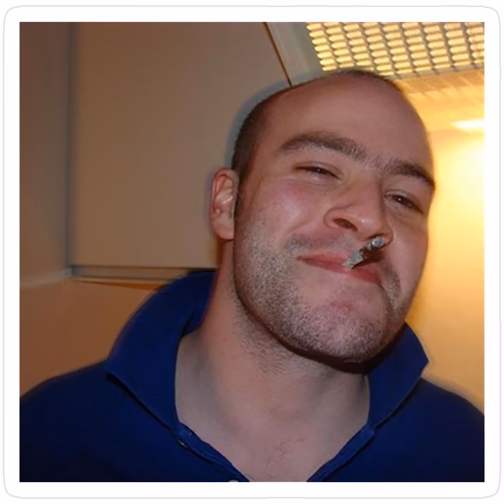 Good Guy Greg original sonriendo con un porro